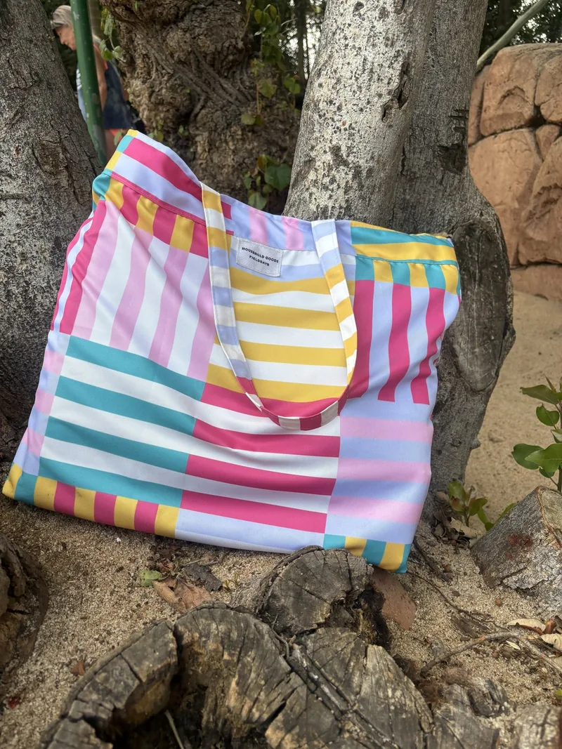 Pink, turquoise, yellow and lilac striped matching bag resting in a tree